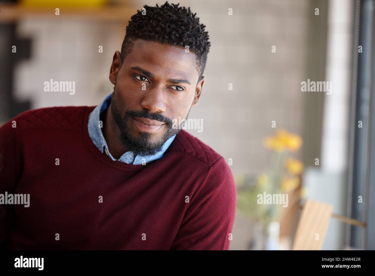 In attesa di qualcuno. Un giovane africano seduto in una caffetteria. Foto Stock