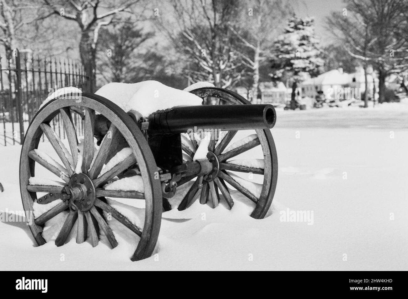 Un canone d'epoca si siede coperto di neve in una giornata invernale in un parco pubblico Foto Stock