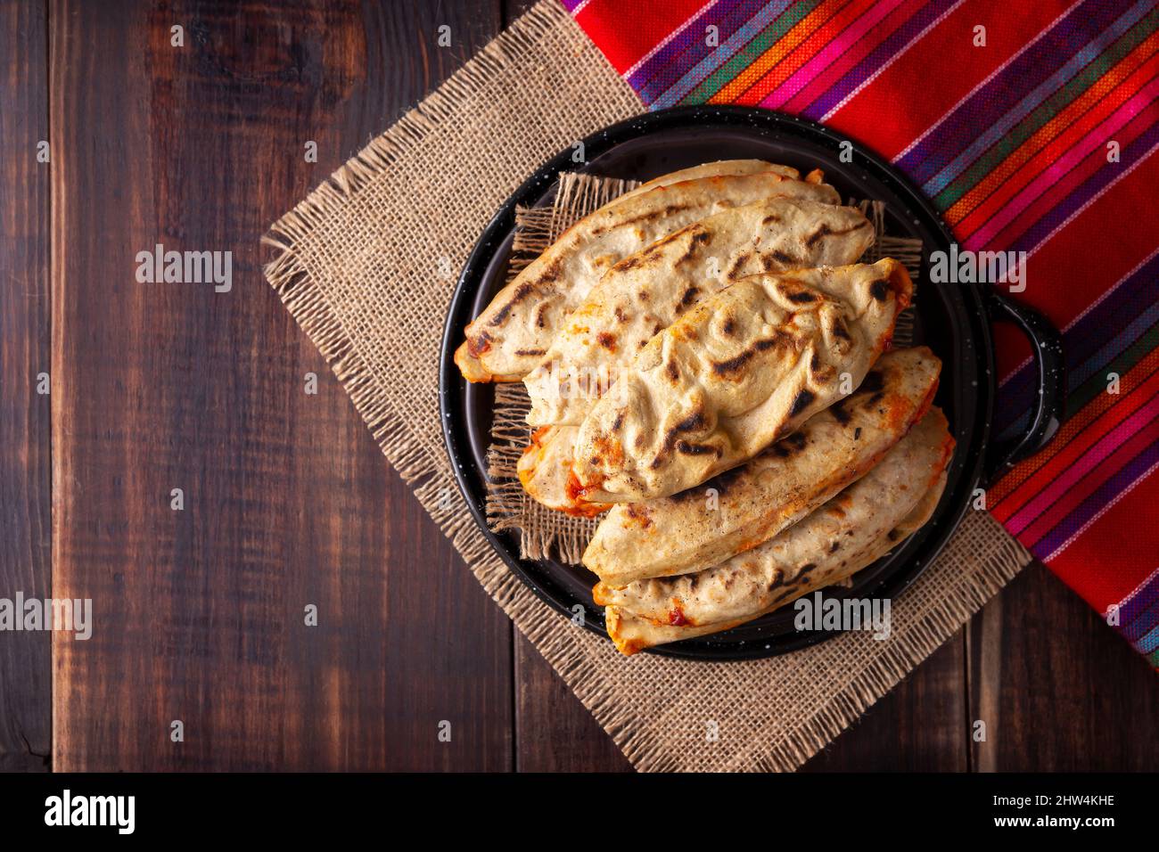 Tlacoyos. Piatto messicano pre-ispanico fatto di paty di farina di mais ripieno di chicharron prensado (rins di maiale pressato). Popolare Street food in Messico. Foto Stock