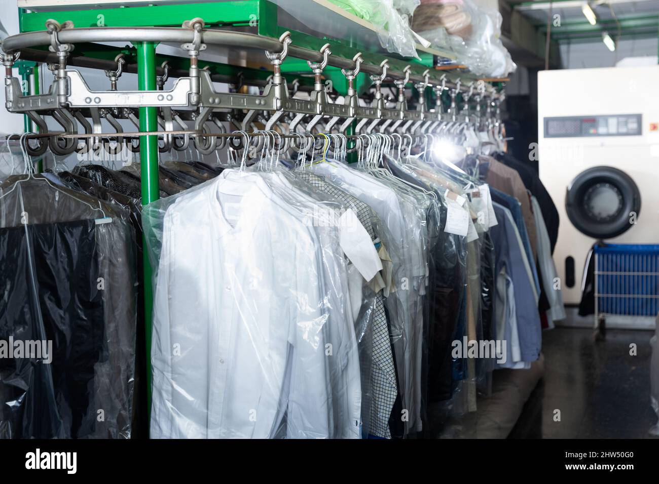 Vestiti in sacchetti di plastica appesi al lavaggio a secco Foto Stock