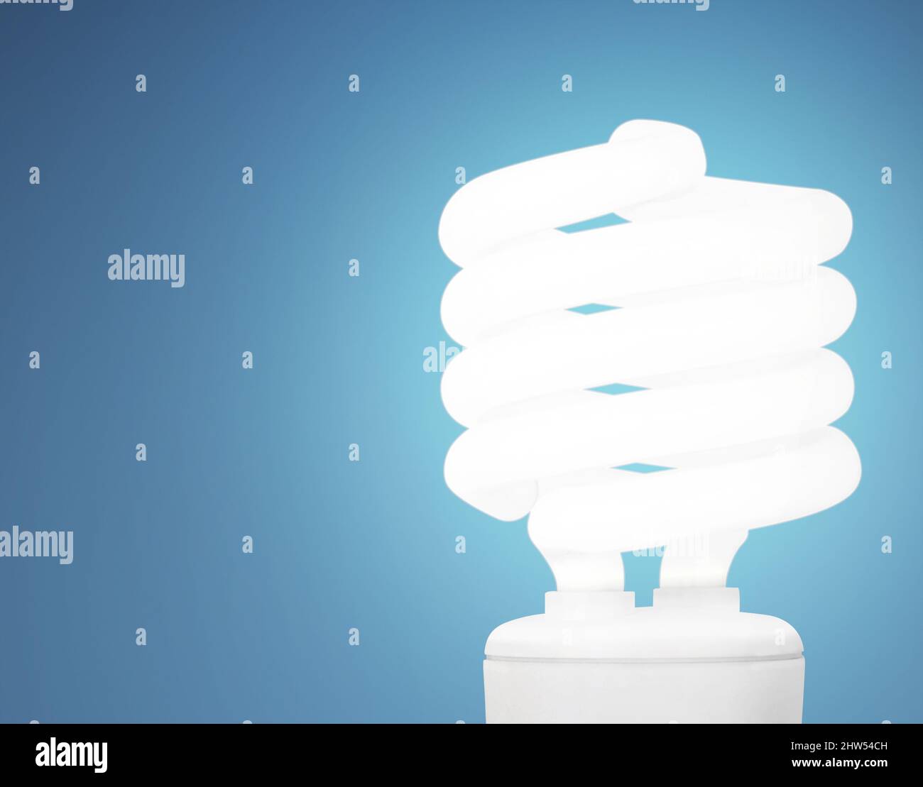 Risparmiate energia. Studio di una lampadina a risparmio energetico su sfondo blu. Foto Stock