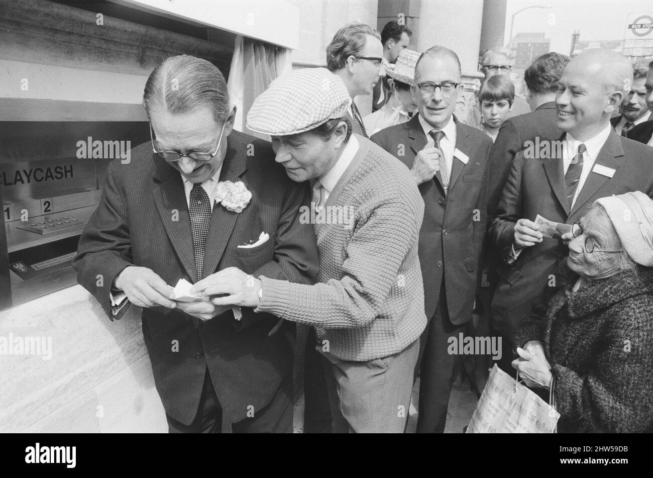 The Worlds First ATM, Cash Machine viene presentato alla Barclays Bank, a Enfield, Middlesex, appena a nord di Londra. 27th giugno 1967. L'immagine mostra l'attore Reg Varney nel suo cappuccio bianco. Barclays ATM, 27th giugno 1967. Sir Thomas Bland, vice presidente della Barclays Bank, rivela una cassa robot che eroga denaro in qualsiasi momento del giorno o della notte. Progettata e sviluppata in collaborazione con De la rue Instruments e con il Dipartimento dei servizi di gestione delle banche, la macchina BarclayCash è installata presso la filiale Enfield. Reg Varney, attore, ha preso il tempo dalle riprese per la serie televisiva "Beggar Your Neighbor" a Northwood To Foto Stock