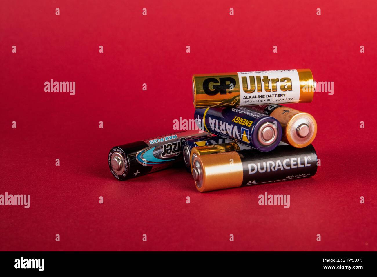 Sigulda, Lettonia - 2 Ferbuary, 2022: Batterie alcaline Duracell, Varta, Energizer, GP Ultra AA su sfondo rosso Foto Stock