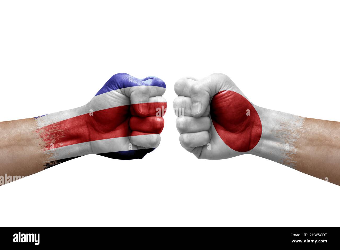 Due mani si pugno l'una all'altra su sfondo bianco. Bandiere di paese dipinte pugni, conflitto concetto di crisi tra costa rica e giappone Foto Stock