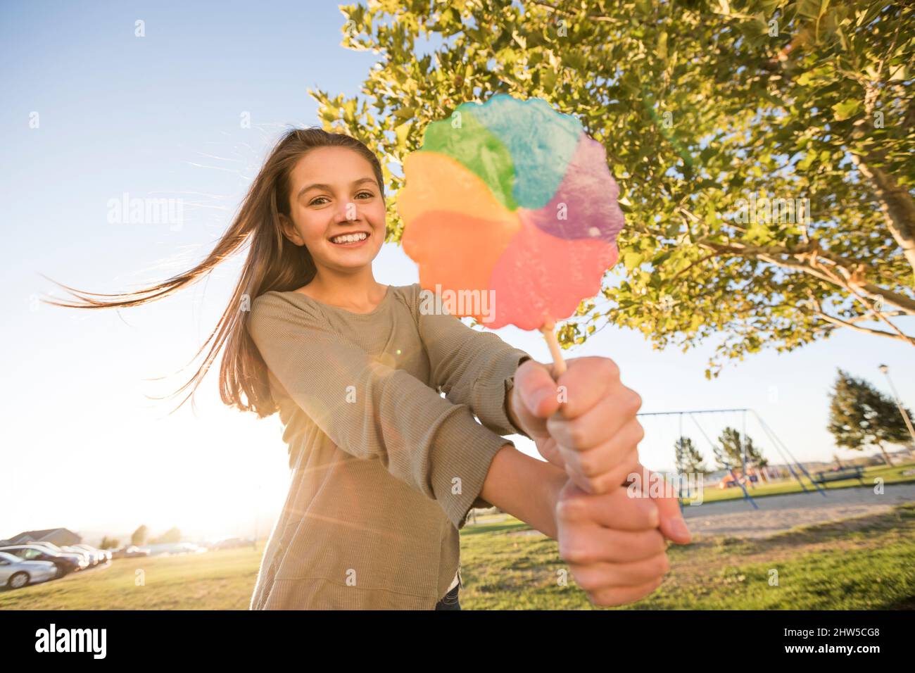 Ritratto di ragazza (12-13) con lollipop colorato nel parco Foto Stock