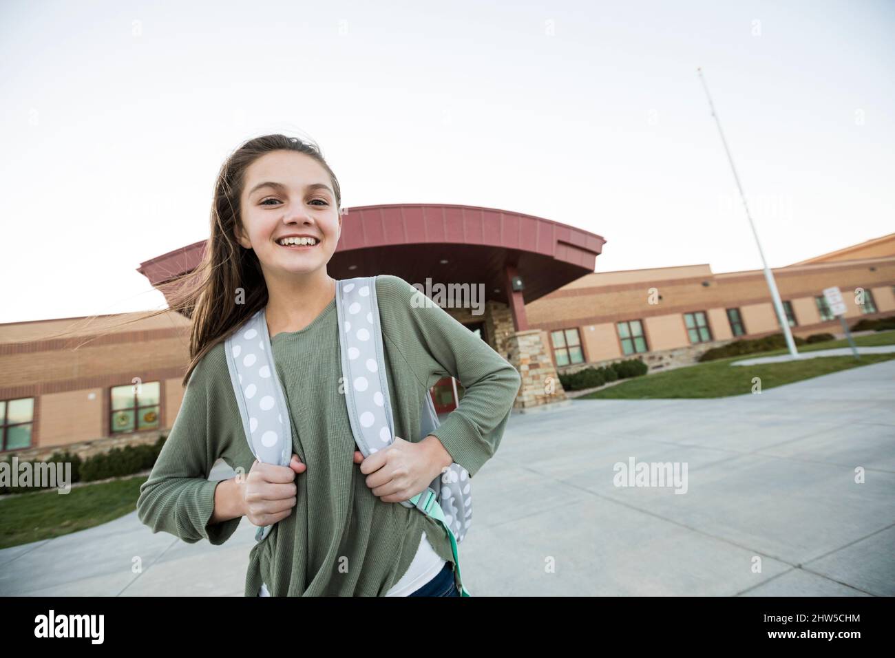 Stati Uniti, Utah, Lehi, Ritratto della ragazza sorridente (12-13) di fronte all'edificio scolastico Foto Stock