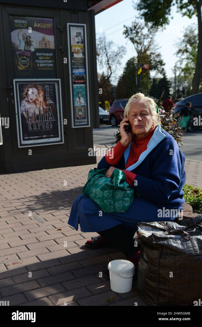 Una vecchia donna Ucraina che parla sul suo cellulare a Kiev, Ucraina. Foto Stock