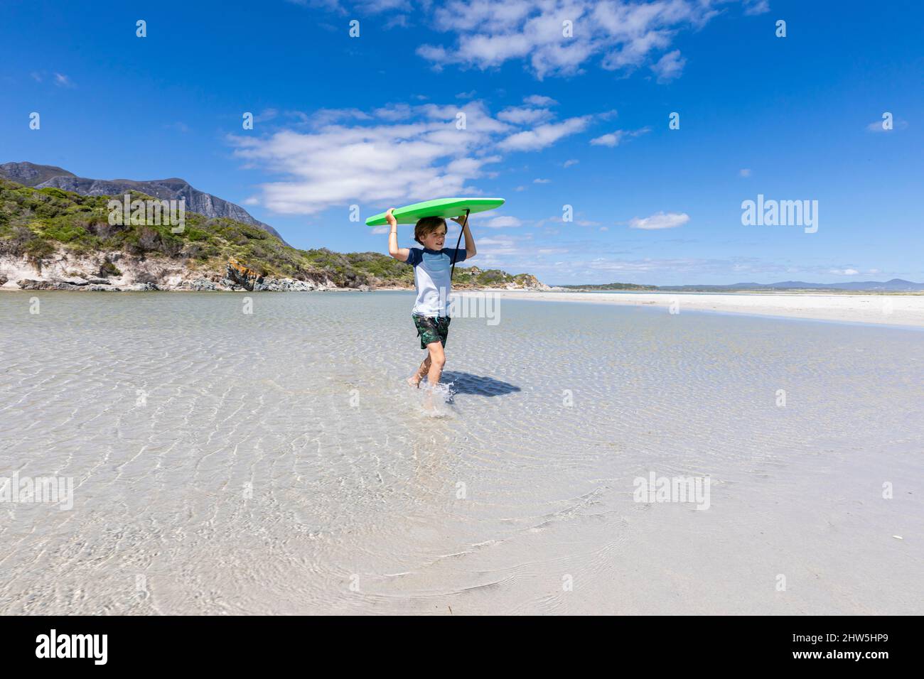 Sud Africa, Hermanus, Boy (8-9) bordo di trasporto del corpo a Grotto Beach Foto Stock