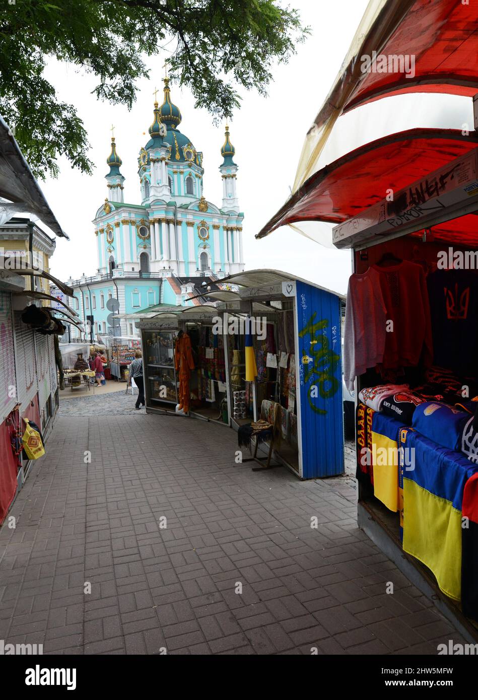 Venditori di artigianato e souvenir lungo Andriivs'kyi discesa con la Chiesa di Sant'Andrea sullo sfondo, Kyiv, Ucraina. Foto Stock
