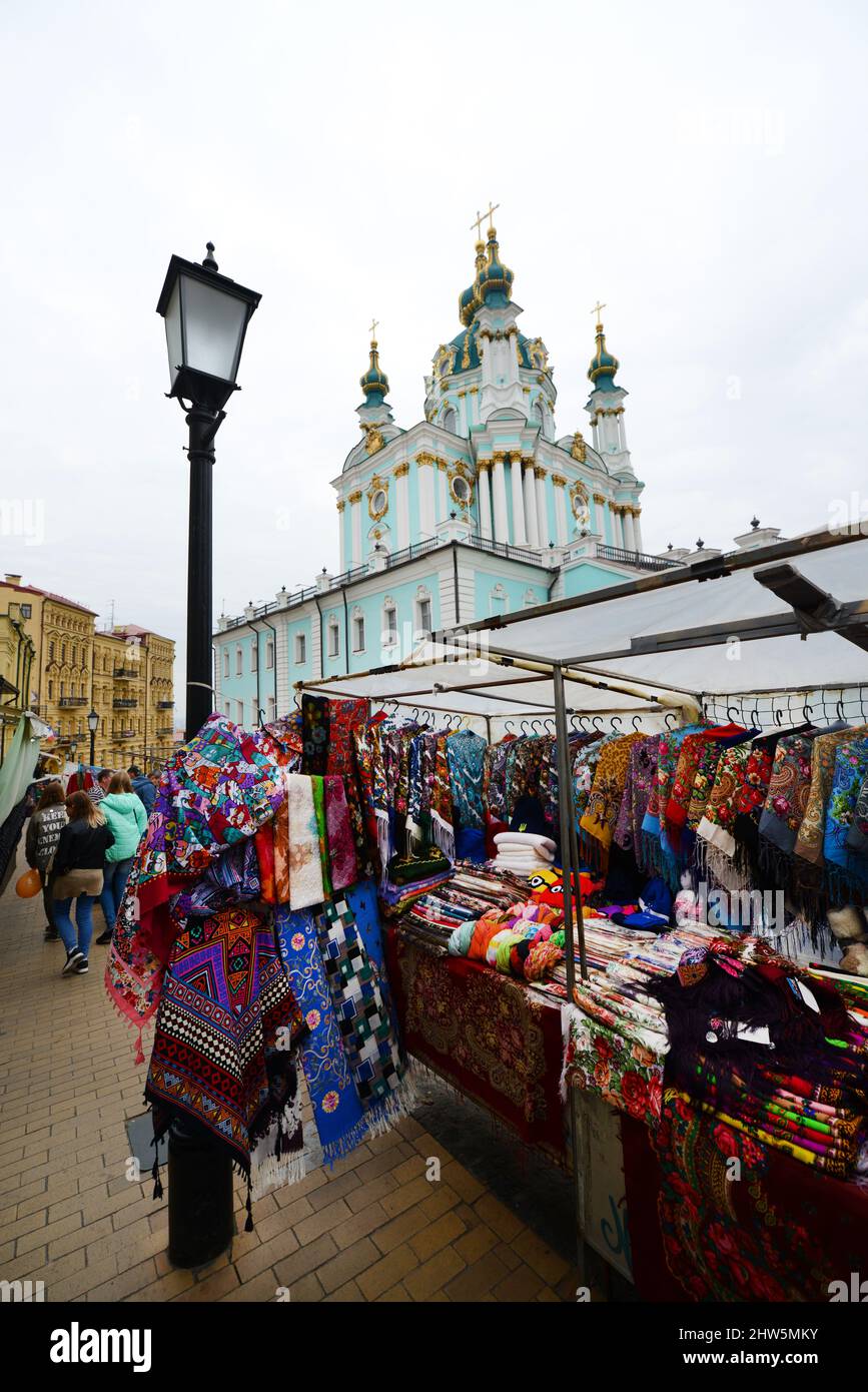 Venditori di artigianato e souvenir lungo Andriivs'kyi discesa con la Chiesa di Sant'Andrea sullo sfondo, Kyiv, Ucraina. Foto Stock