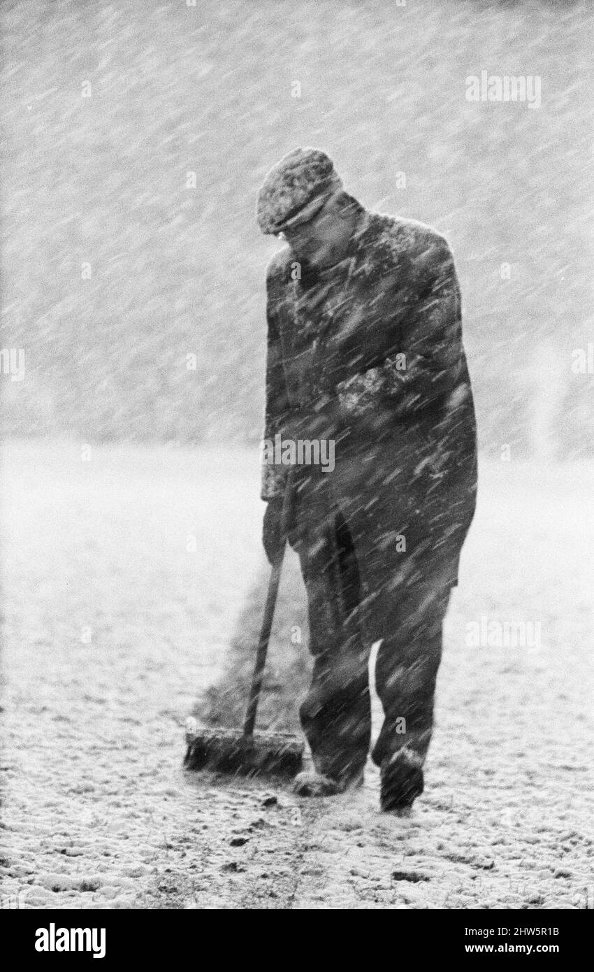 Campionato inglese Divisione uno partita a Highbury, abbandonato a causa della neve pesante. Arsenal / Sheffield Mercoledì. Un membro del groundsman che spazzano il campo. 9th dicembre 1967. Foto Stock