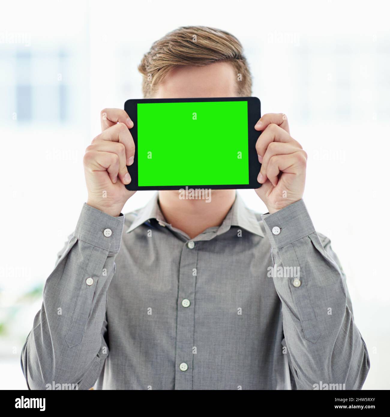 Hai capito. Scatto di un uomo che tiene un tablet digitale con uno schermo a tasti cromati davanti al suo volto. Foto Stock