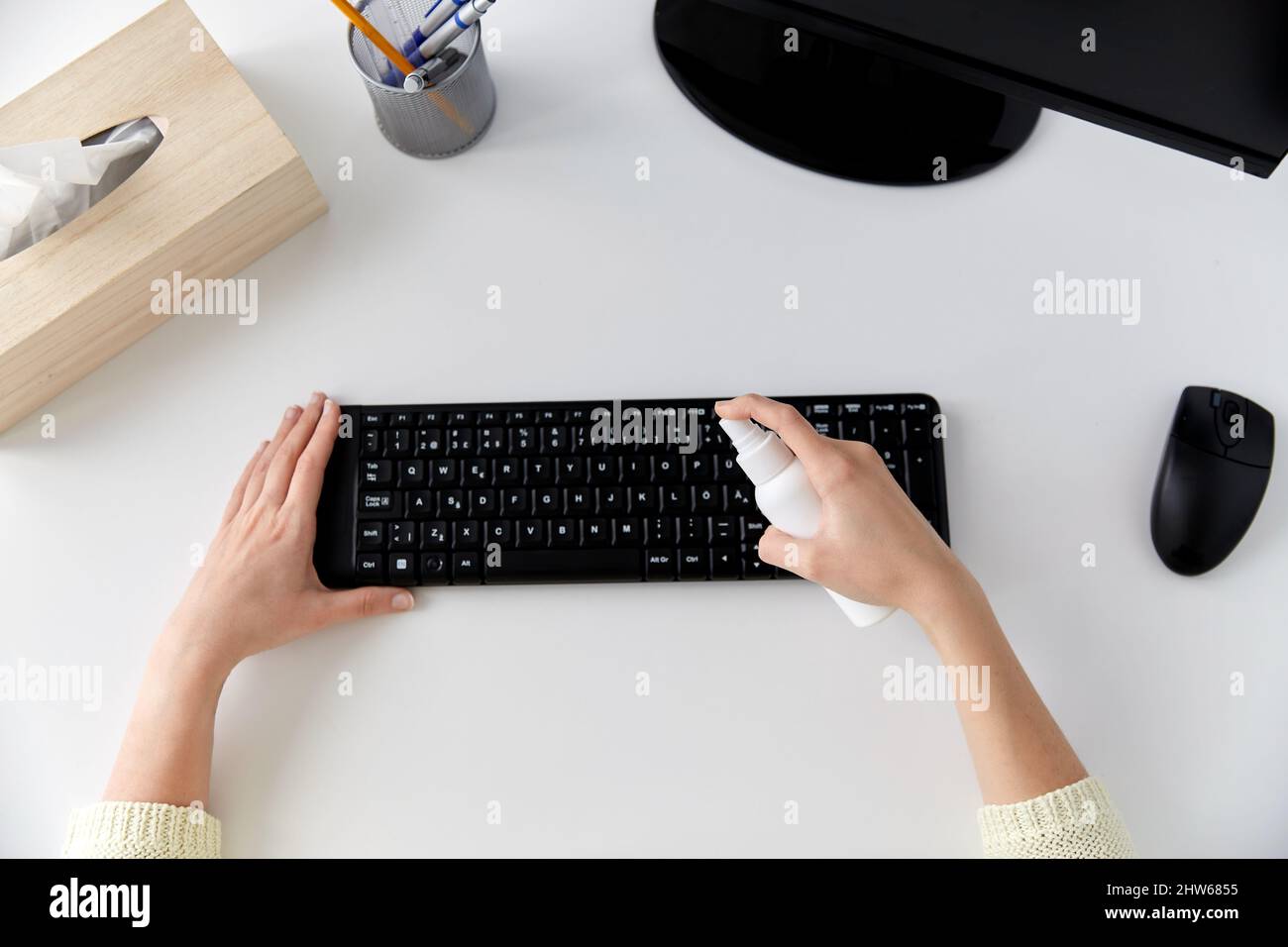 primo piano della donna che pulisce la tastiera con igienizzatore Foto Stock