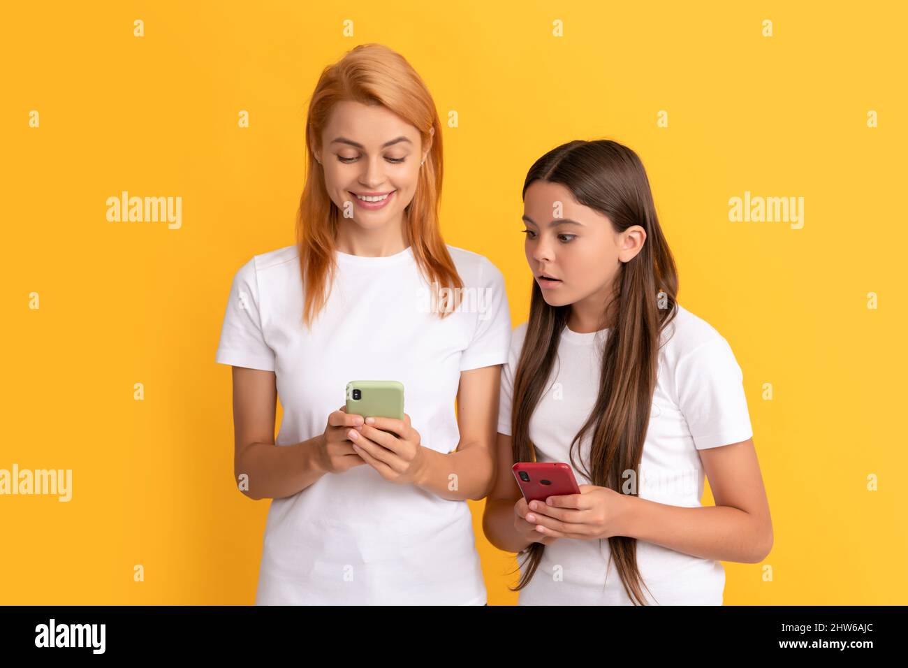moderna tecnologia di comunicazione. digitazione e texting di madre e figlia. Foto Stock