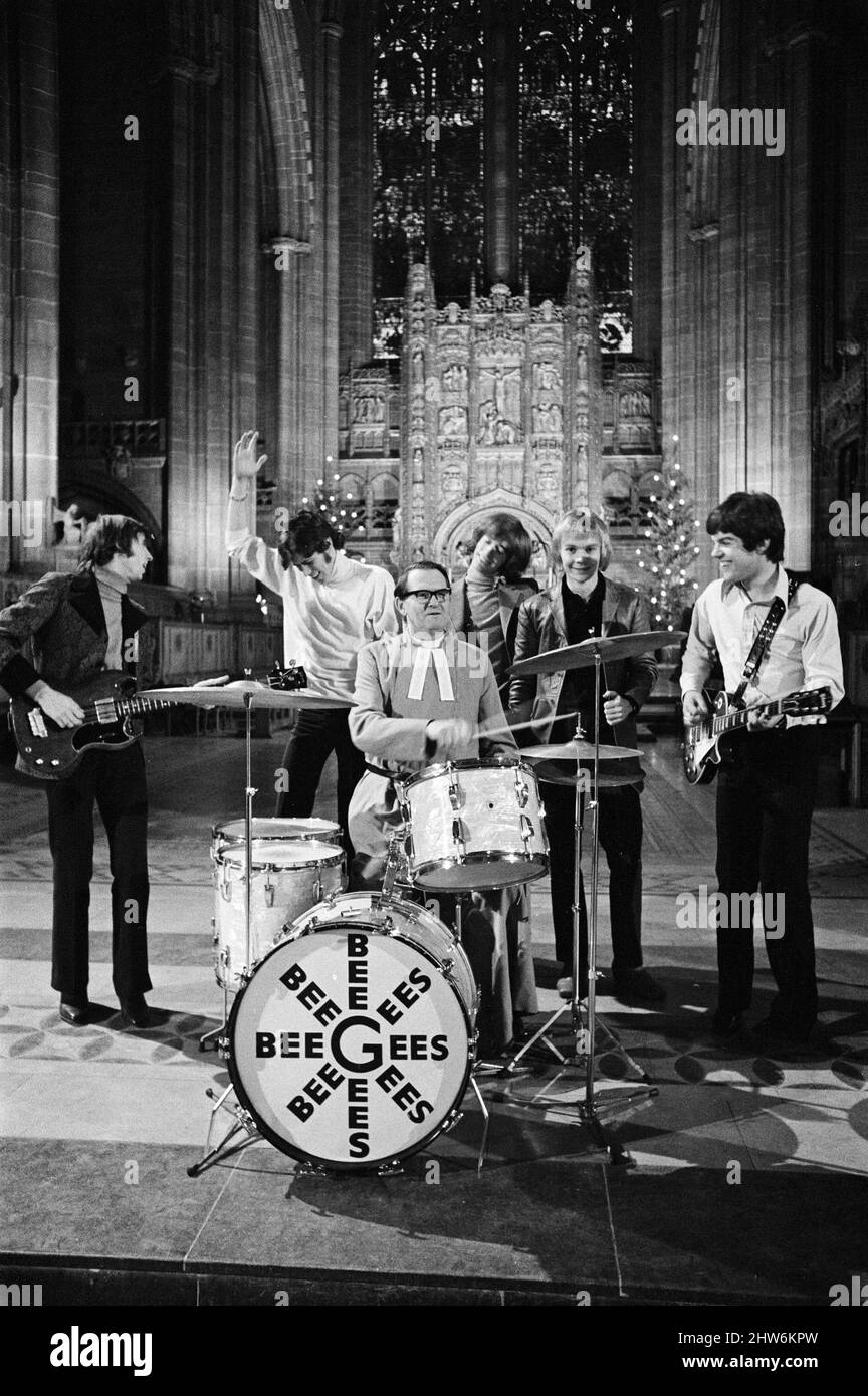 I Bee Gees si esibiscono presso la cattedrale anglicana di Liverpool. I Bee Gees sono i fratelli Maurice, Barry e Robin Gib, Colin Peterson e vince Malouney. Il decano di Liverpool, il Rev. Edward Patey non poteva resistere a provare i tamburi. 14th dicembre 1967. Foto Stock