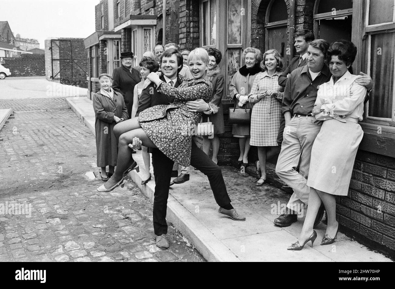 Una nuova strada per 'Coronation Street'. Granada TV hanno costruito un set per l'esterno per riprendere alcune scene. Nella foto sono presenti membri del cast: Il membro del cast Dennis Tanner (Philip Lowrie) con la sua sposa Jenny Sutton (Mitzi Rogers) dopo il matrimonio con Annie Walker (Doris Speed), Ena Sharples (Violet Carson), Emily Nugent (Eileen Derbyshire), Valerie Barlow (Anne Reid), Ken Barlow (William Roache) e Peter Elprensie (Phoenix). 18th maggio 1968. Foto Stock