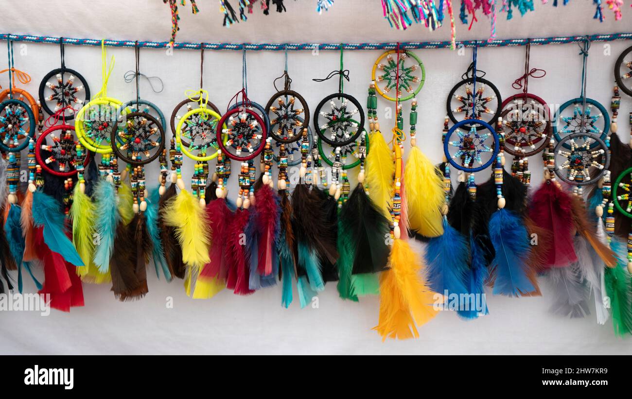 Quito, Pichincha, Ecuador - Febbraio 26 2022: Gruppo di draghe multicolore con piume fatte a mano da ecuadoriani indigeni per la vendita in an Foto Stock