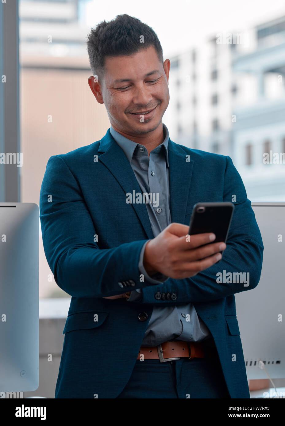 Non piegare mai la testa. Tenerlo sempre alto. Scatto di un giovane che usa un cellulare in ufficio. Foto Stock