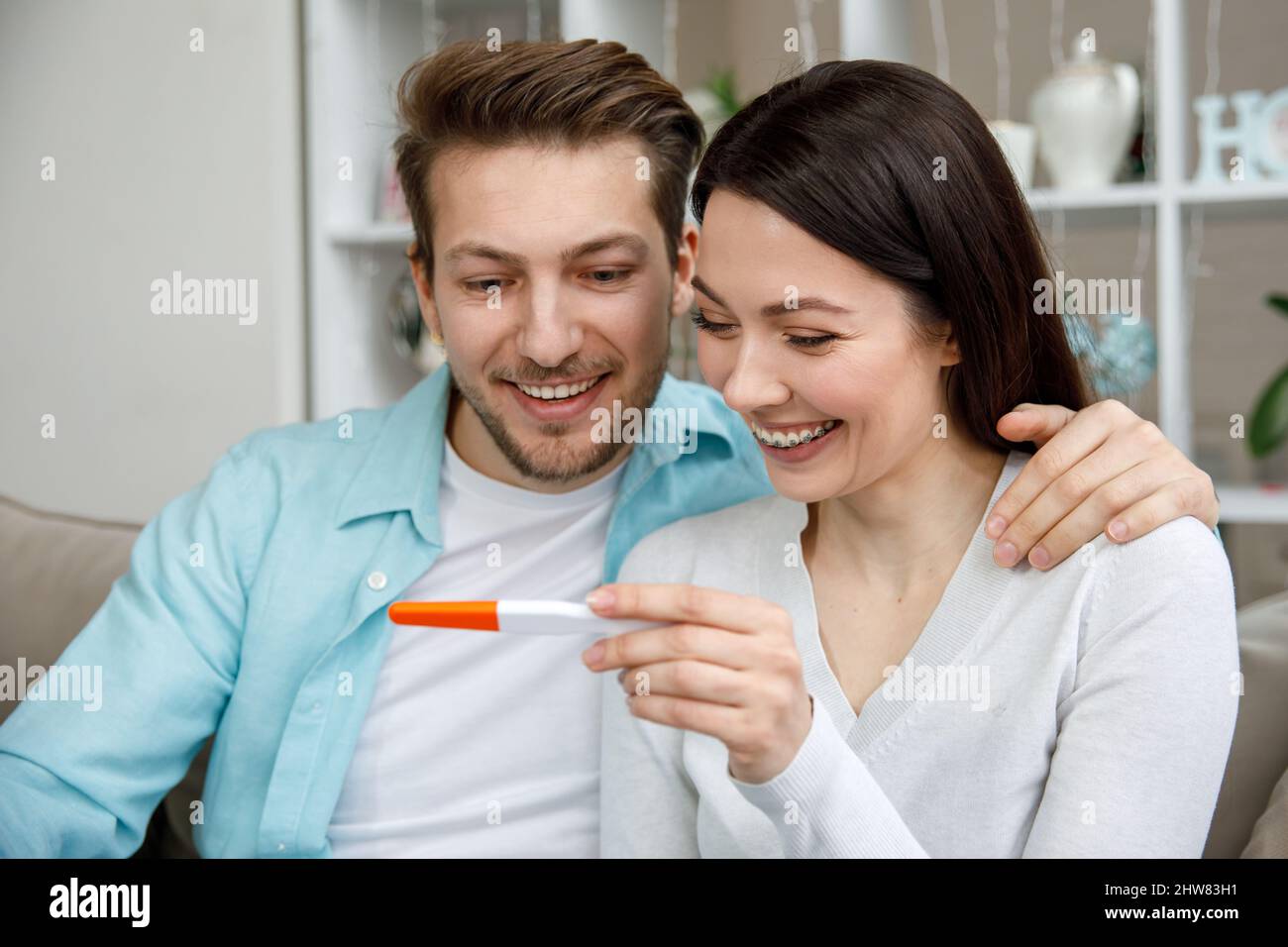 Donna che sorprende suo marito con test di gravidanza positivo, Foto Stock