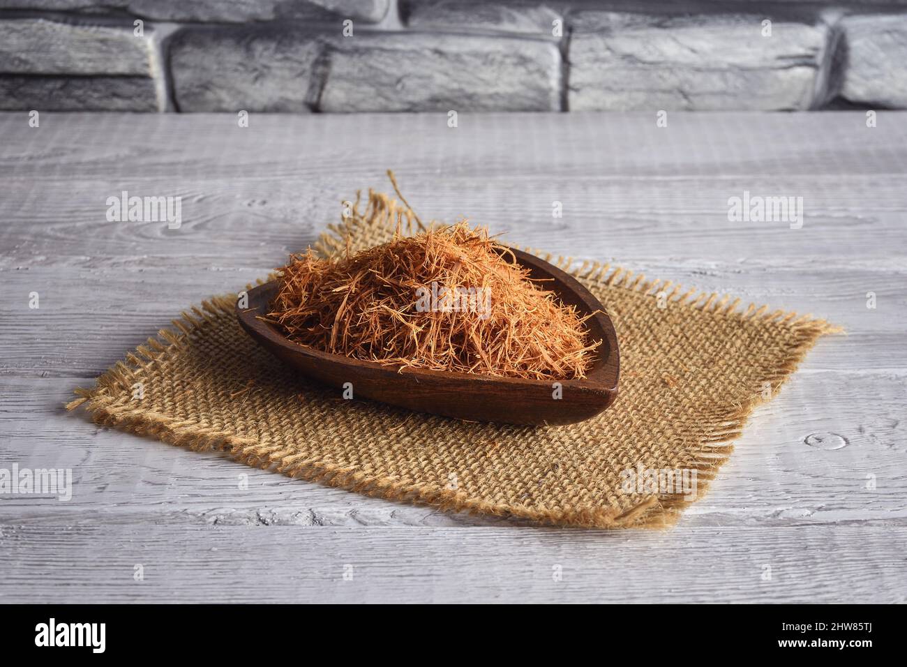 Buone erbe per immunità. Artiglio di gatto su una ciotola di legno. Foto Stock