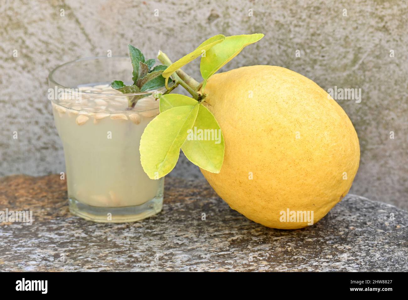 primo piano il pompelmo giallo con succo di frutta e menta su sfondo grigio marrone fuori fuoco. Foto Stock