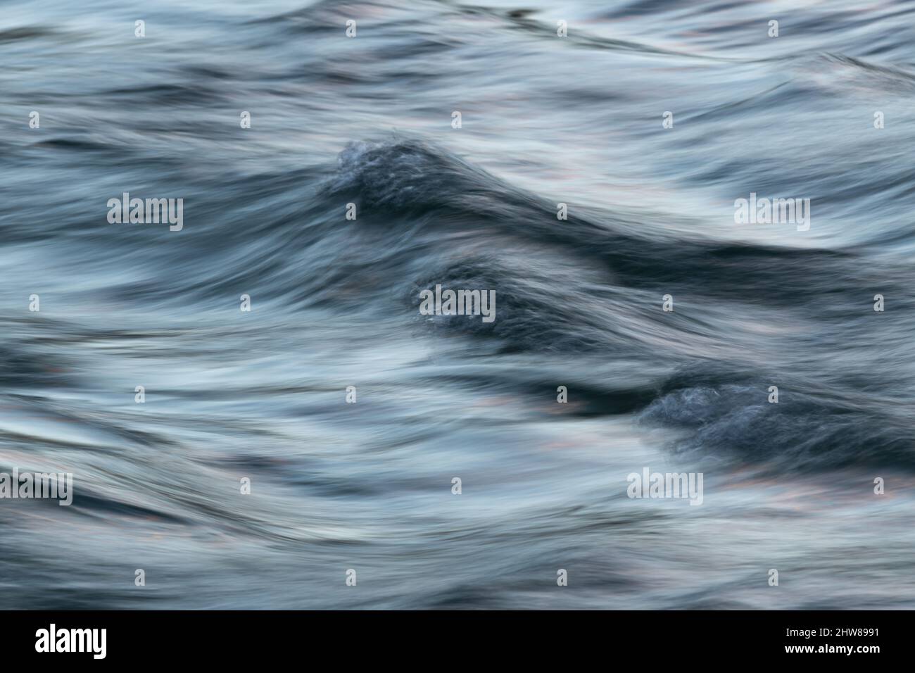 Acqua turbolenta ondulata con superficie setosa a lunga esposizione ed effetto motion blur - paesaggio astratto Foto Stock