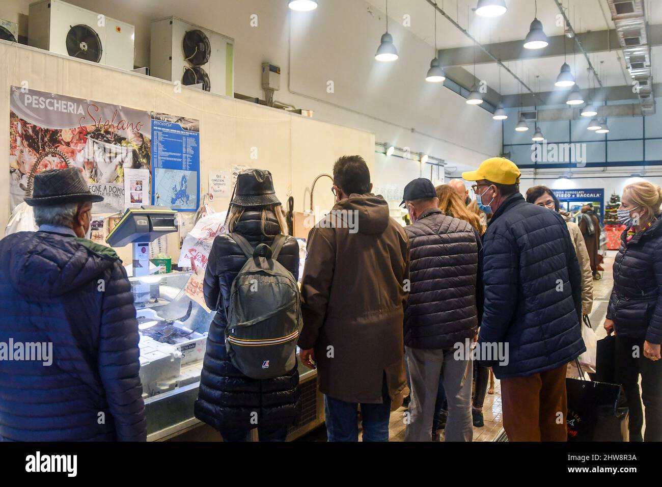 Persone che si accanono per comprare pesce fresco al mercato Annonario nel centro storico di Sanremo, Imperia, Liguria, Italia Foto Stock