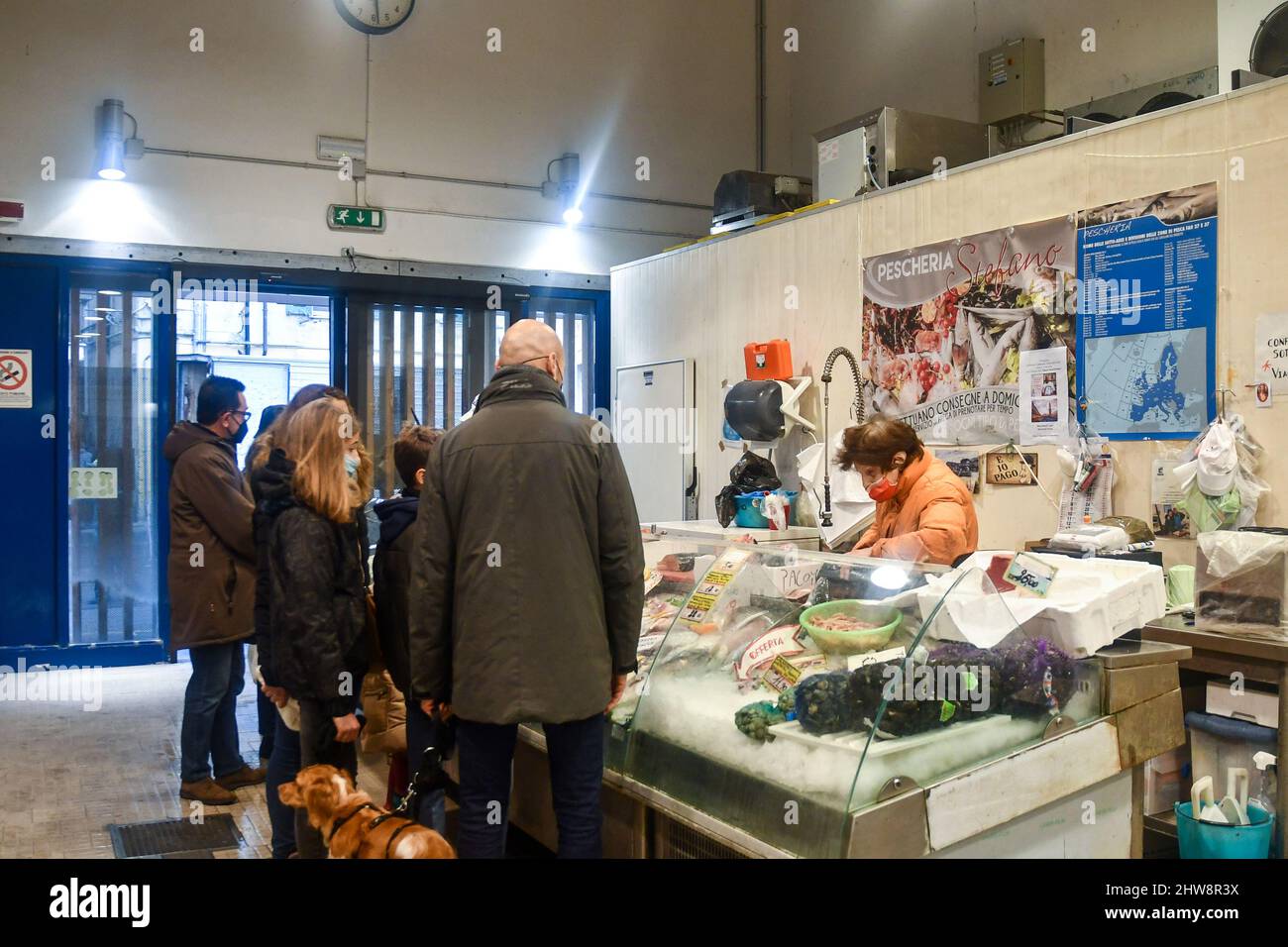 Persone che si accanono per comprare pesce fresco al mercato Annonario nel centro storico di Sanremo, Imperia, Liguria, Italia Foto Stock