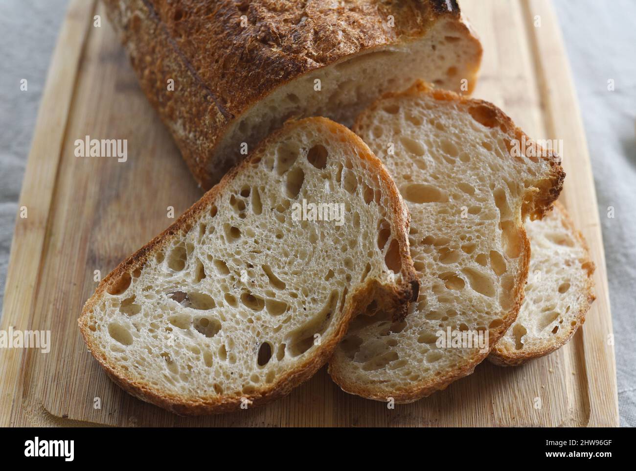 Una pagnotta affettata di pane fatto in casa su un asse di legno Foto Stock