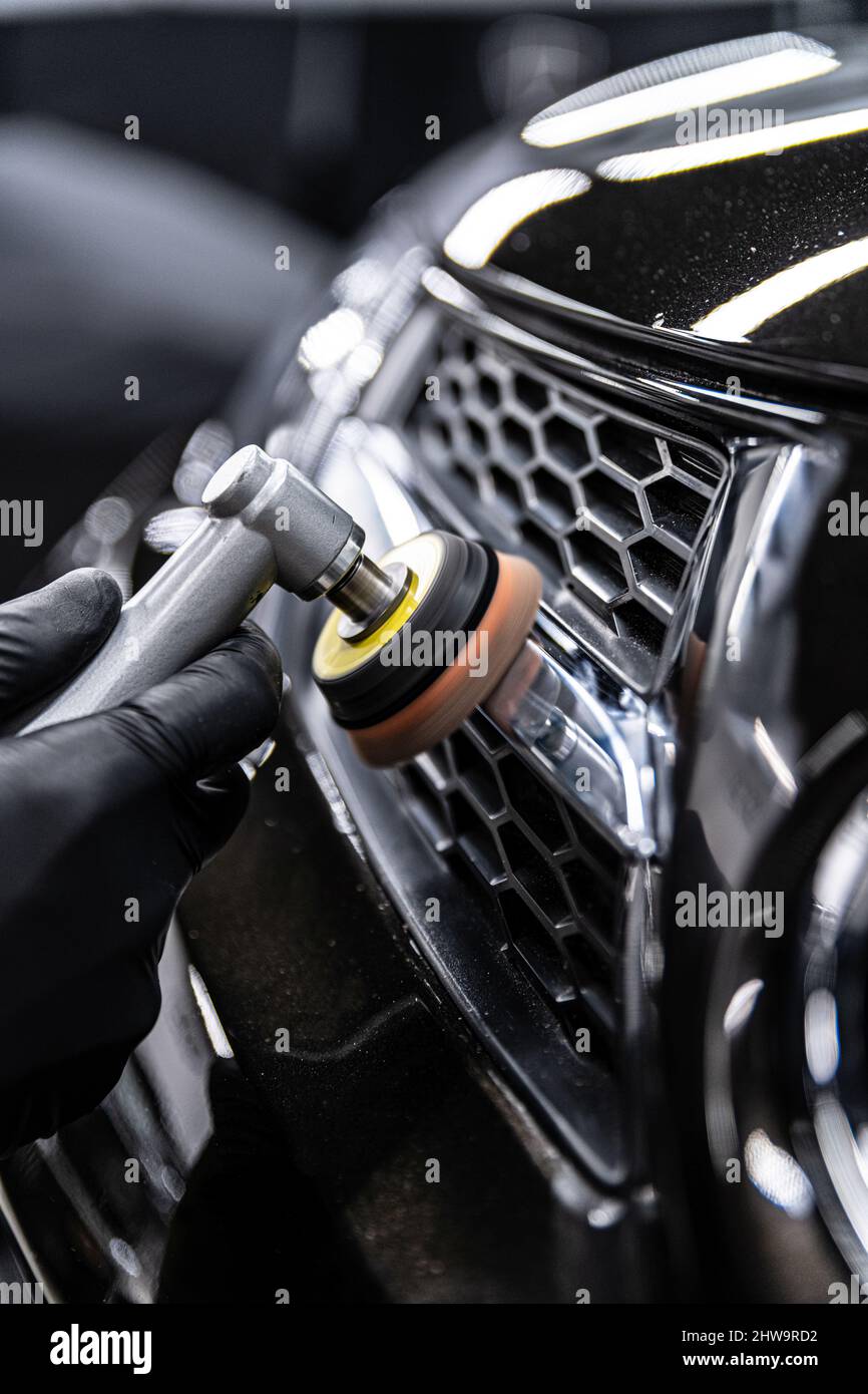 Tecnico di dettaglio auto lucidando cromo lucido decorazione su auto Foto Stock