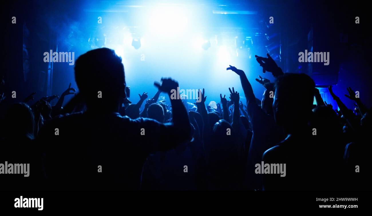 Una folla di persone che guardano una band sul palco in un nightclub. Questo concerto è stato creato per il solo scopo di questa foto, con 300 Foto Stock