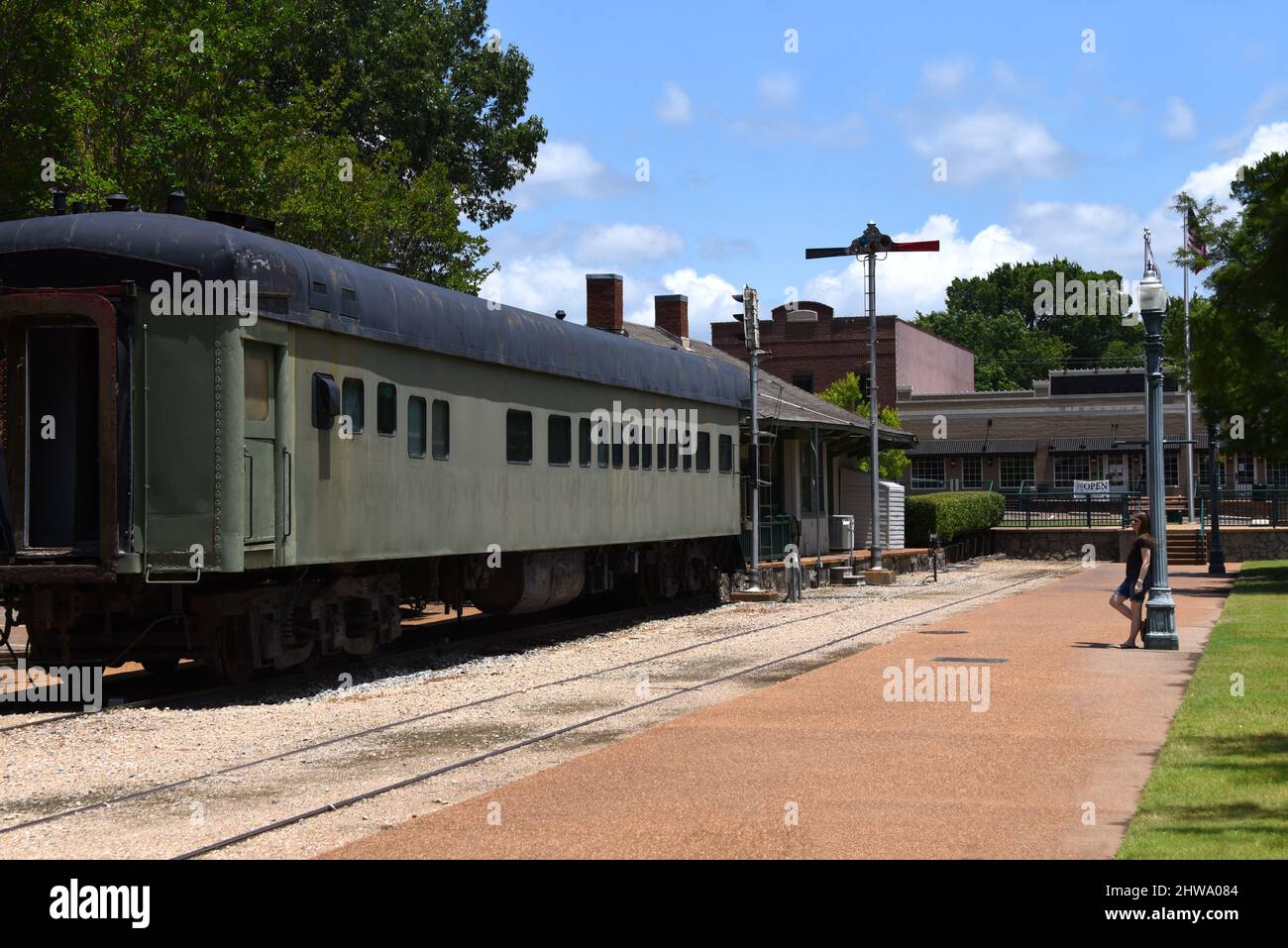 La giovane donna si appoggia contro un lampione decorativo presso lo storico Collierville Train Depot a Collierville, Tennessee. Foto Stock