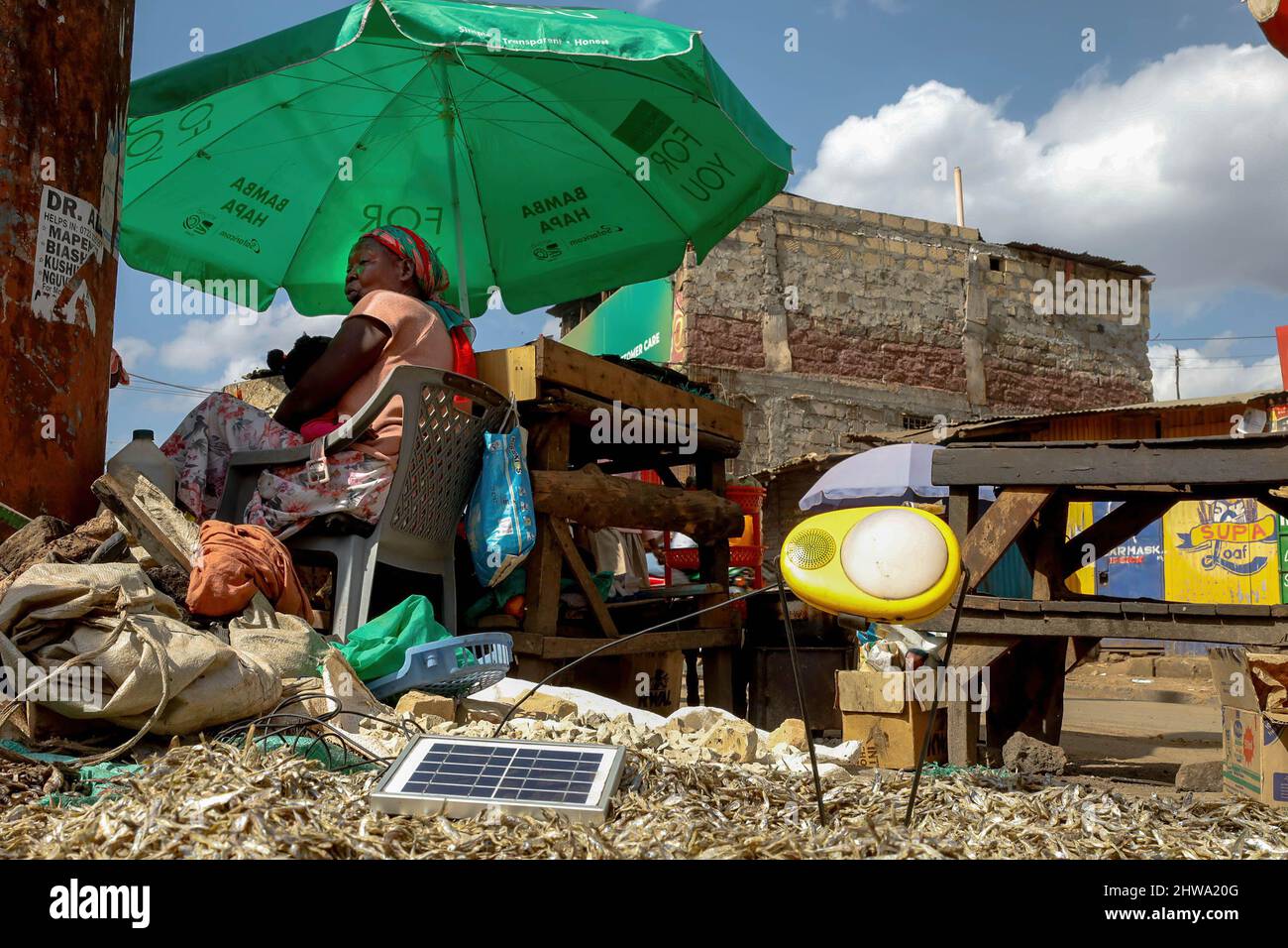 Un venditore di strada siede vicino al suo commercio di strada mentre carica la sua lampada ad energia solare nelle baraccopoli di Kibera. Nelle baraccopoli di Kibera, la maggior parte dei residenti, in particolare i venditori ambulanti, le scuole private, le organizzazioni non governative, le luci di strada e le scuole, utilizzano tutti il sistema di energia solare a basso costo, che è una fonte di energia più affidabile e a basso costo. Ciò ha reso più facile il riciclaggio della maggior parte dell'energia elettrica consumata dai residenti e ha anche contribuito a ridurre l'elevato numero di morti che si verificano a causa delle scosse elettriche e degli incendi di slum quotidiani. (Foto di Donwilson Odhiambo/SOPA Images/Sipa USA) Foto Stock