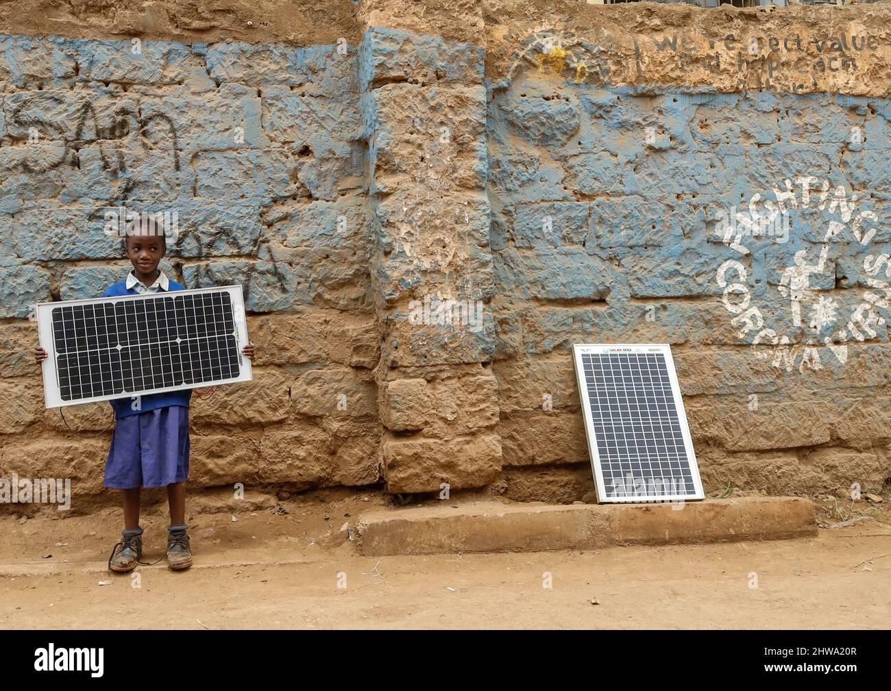 Una giovane ragazza della scuola ha visto portare un pannello solare per le strade di Kibera. Nelle baraccopoli di Kibera, la maggior parte dei residenti, in particolare i venditori ambulanti, le scuole private, le organizzazioni non governative, le luci di strada e le scuole, utilizzano tutti il sistema di energia solare a basso costo, che è una fonte di energia più affidabile e a basso costo. Ciò ha reso più facile il riciclaggio della maggior parte dell'energia elettrica consumata dai residenti e ha anche contribuito a ridurre l'elevato numero di morti che si verificano a causa delle scosse elettriche e degli incendi di slum quotidiani. (Foto di Donwilson Odhiambo/SOPA Images/Sipa USA) Foto Stock