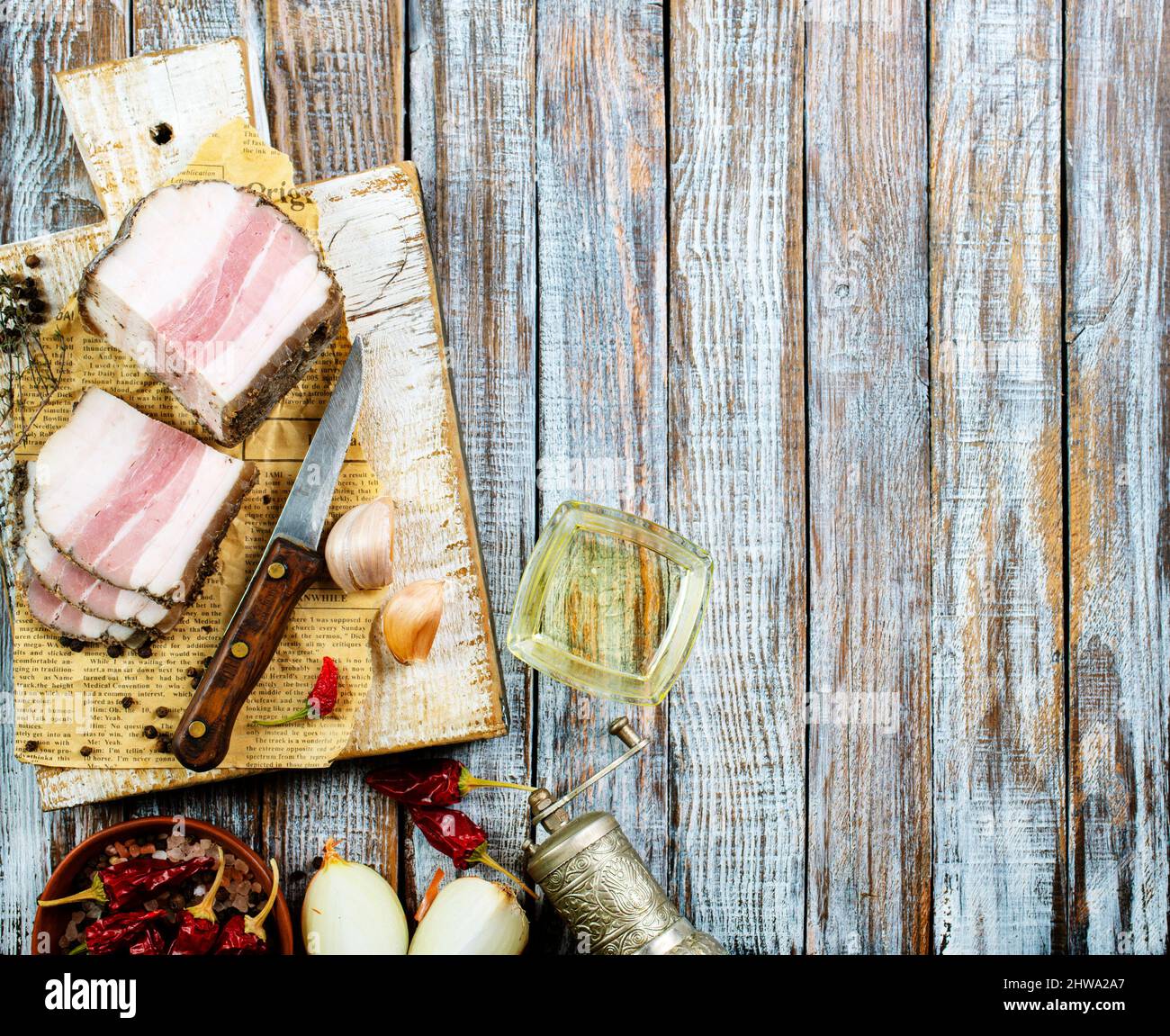 Pezzi di pancetta salata su sfondo scuro. Cibo sano con pranami spezie ed erbe. Salato grasso, lardo, sego, grasso Foto Stock