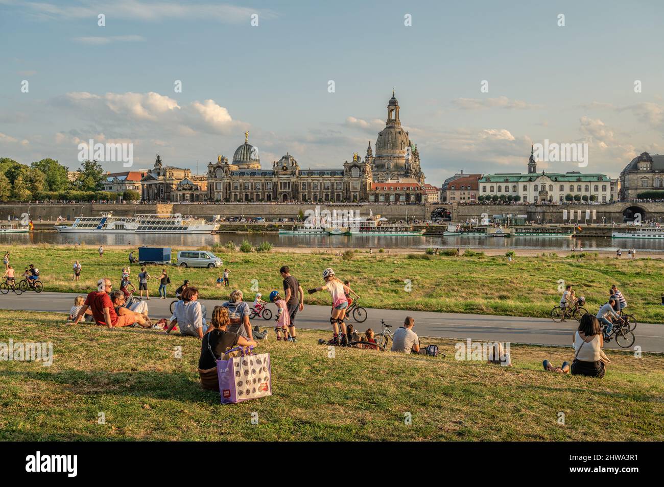 Gli abitanti del luogo si godono il crepuscolo sul fiume Elba di fronte allo skyline di Dresda, Sassonia, Germania Foto Stock