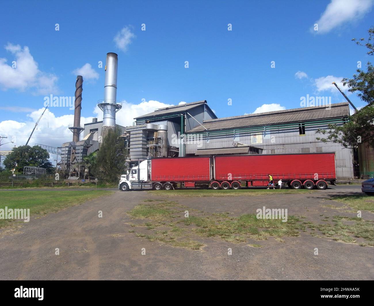 Treno stradale rosso di fronte alla raffineria di zucchero , Australia, Queensland Foto Stock