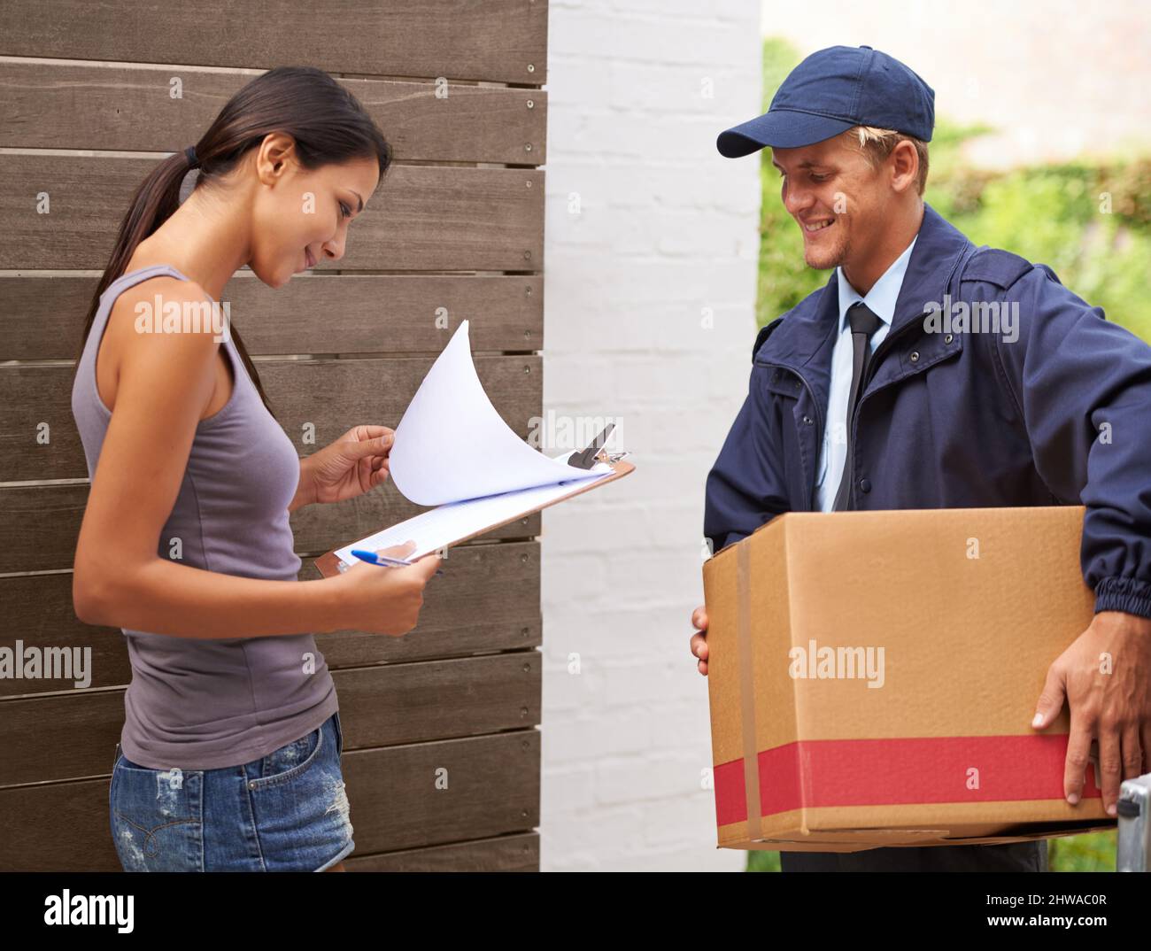 Assicurarsi che la documentazione sia in ordine. Scatto ritagliato di una bella donna che riceve una consegna. Foto Stock