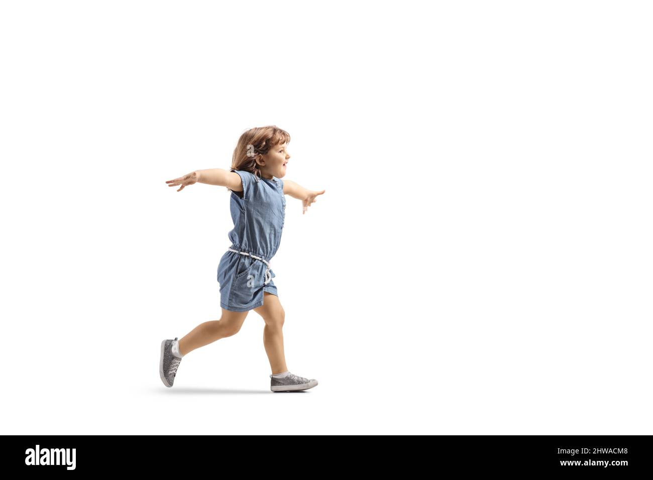 Scatto a tutto profilo di una ragazza felice che corre e stendendo braccia isolate su sfondo bianco Foto Stock