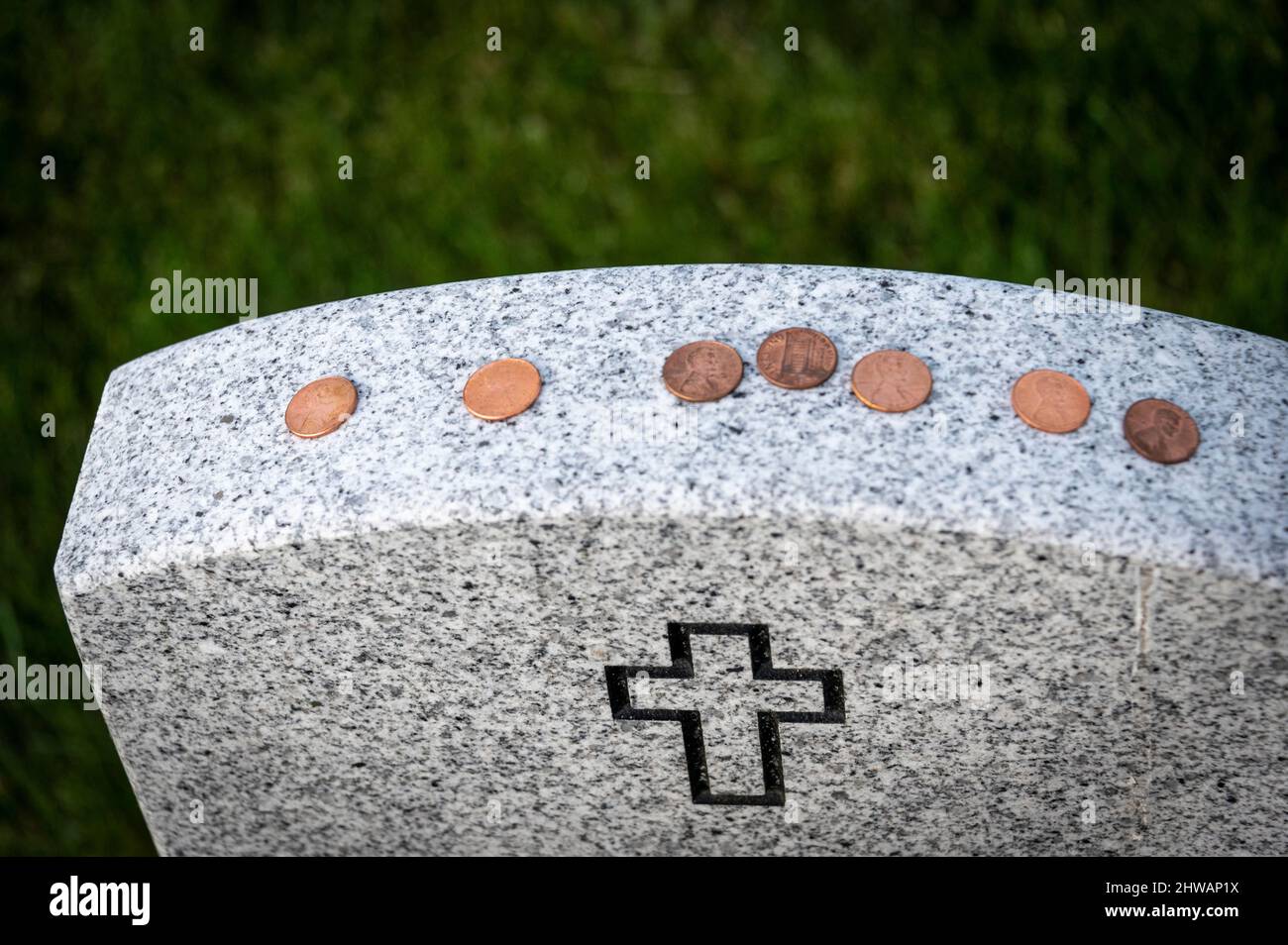 Pennies sulla cima di una headstone cristiana dai visitatori passati Foto Stock