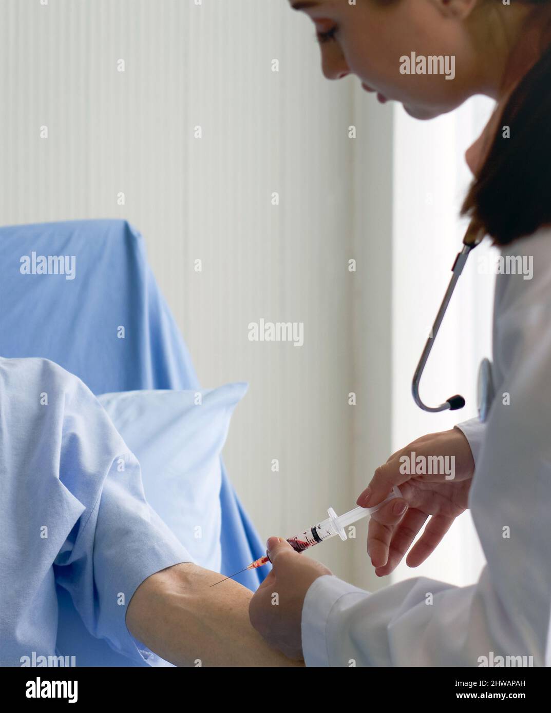 Giovane medico caucasico raccoglie il campione di sangue dal paziente. Coronavirus malattia 2019 processo di test in un ospedale. Foto Stock