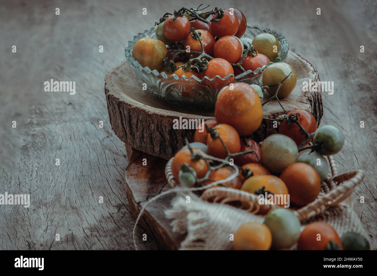 Gruppo di variegata varietà di pomodori freschi (Mini Cherry Tomatos) su vecchio sfondo di legno tavola. Messa a fuoco selettiva. Foto Stock