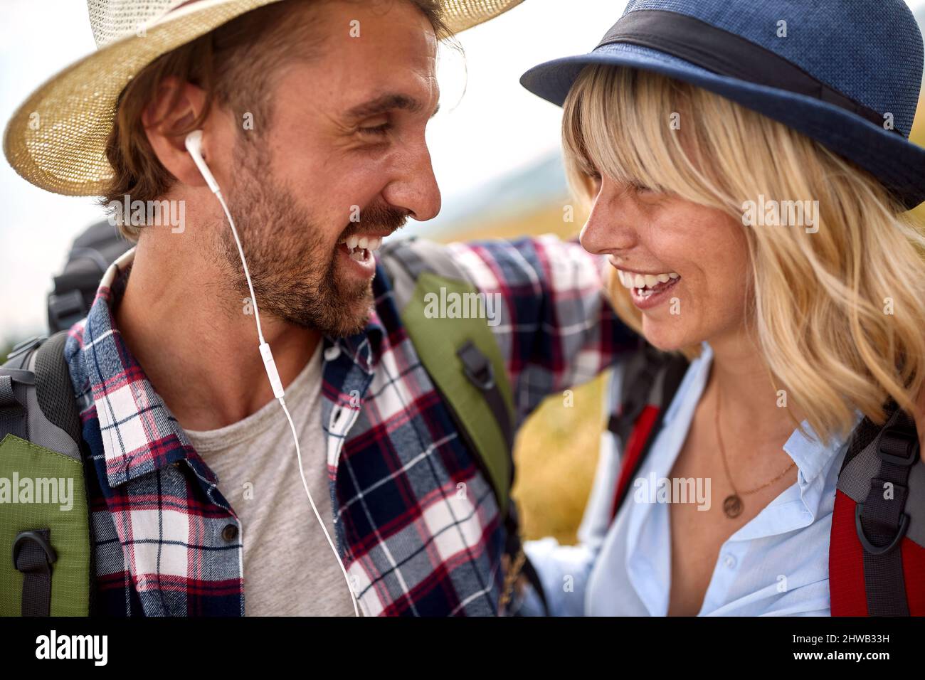 Primo piano di una giovane coppia felice innamorata mentre si cammina un prato in una bella giornata di sole. Escursioni, natura, relazione, insieme Foto Stock