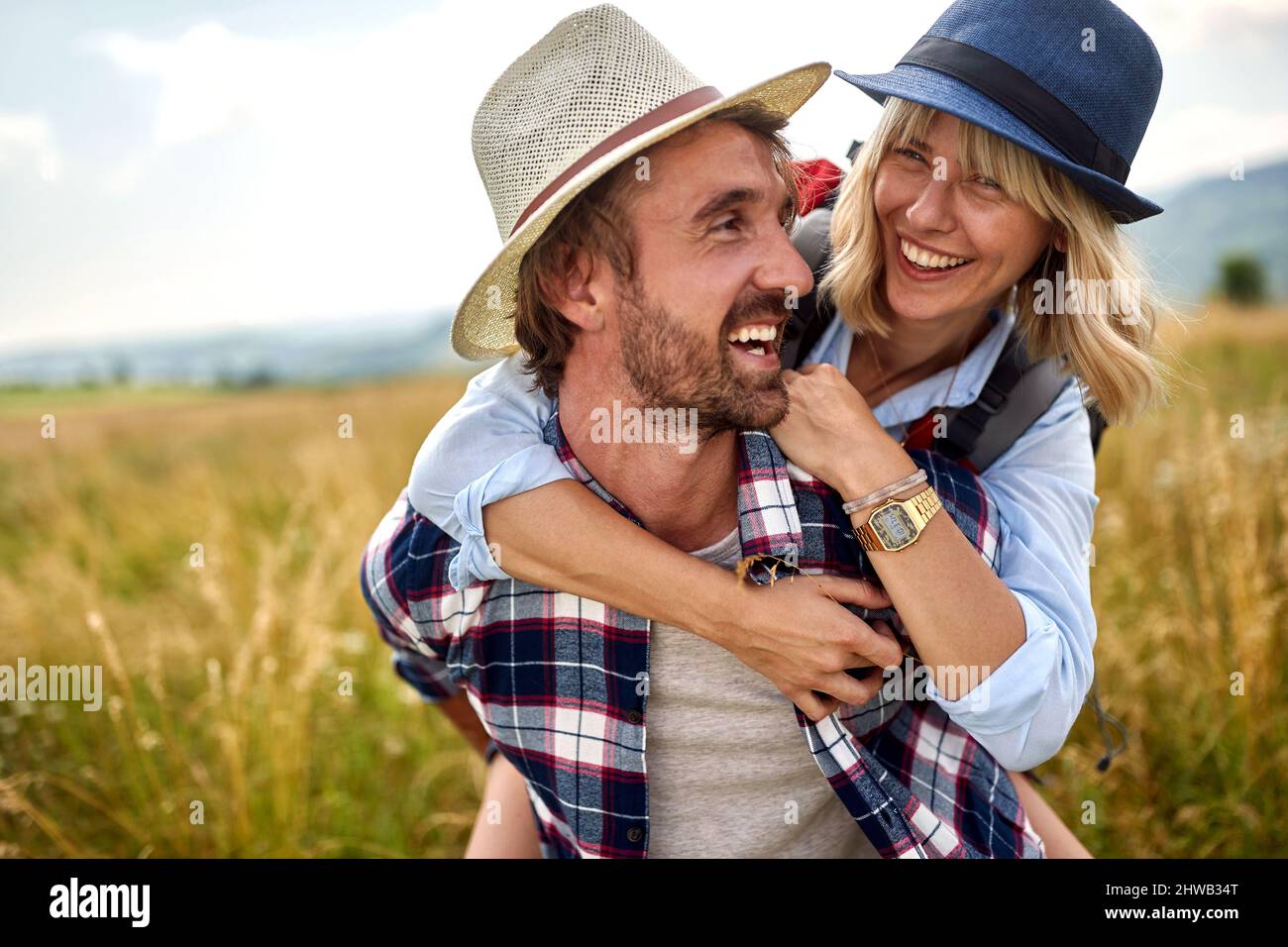Incontro nella natura. Uomo che porta la sua ragazza sorridente su piggyback. Foto Stock