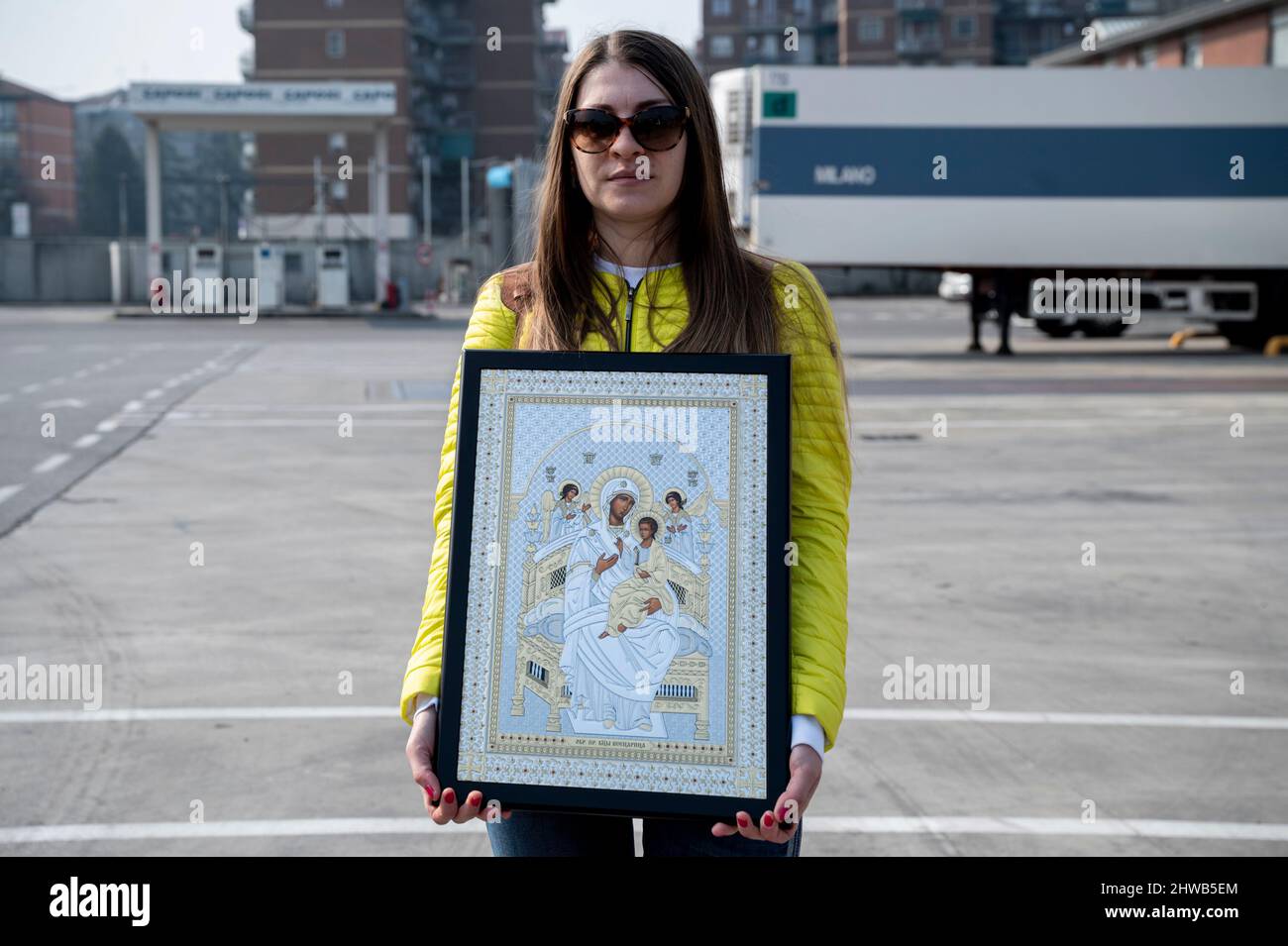 Milano, Italia. 04th Mar 2022. Una giovane ragazza ha un'icona dell'icona della Vergine Maria quasi 15 veicoli, che trasportano aiuti umanitari, organizzati dalla Chiesa Ortodossa di San Nicola e Ambrogio al Lazzaretto a Milano, partono il 4th marzo per portare abiti, cibo e beni di prima necessità a persone in Ucraina, attraversando la Romania. L'Arcivescovo Avondios Bica guida il convoglio fino a Chernivtsi, Ucraina. Credit: SOPA Images Limited/Alamy Live News Foto Stock