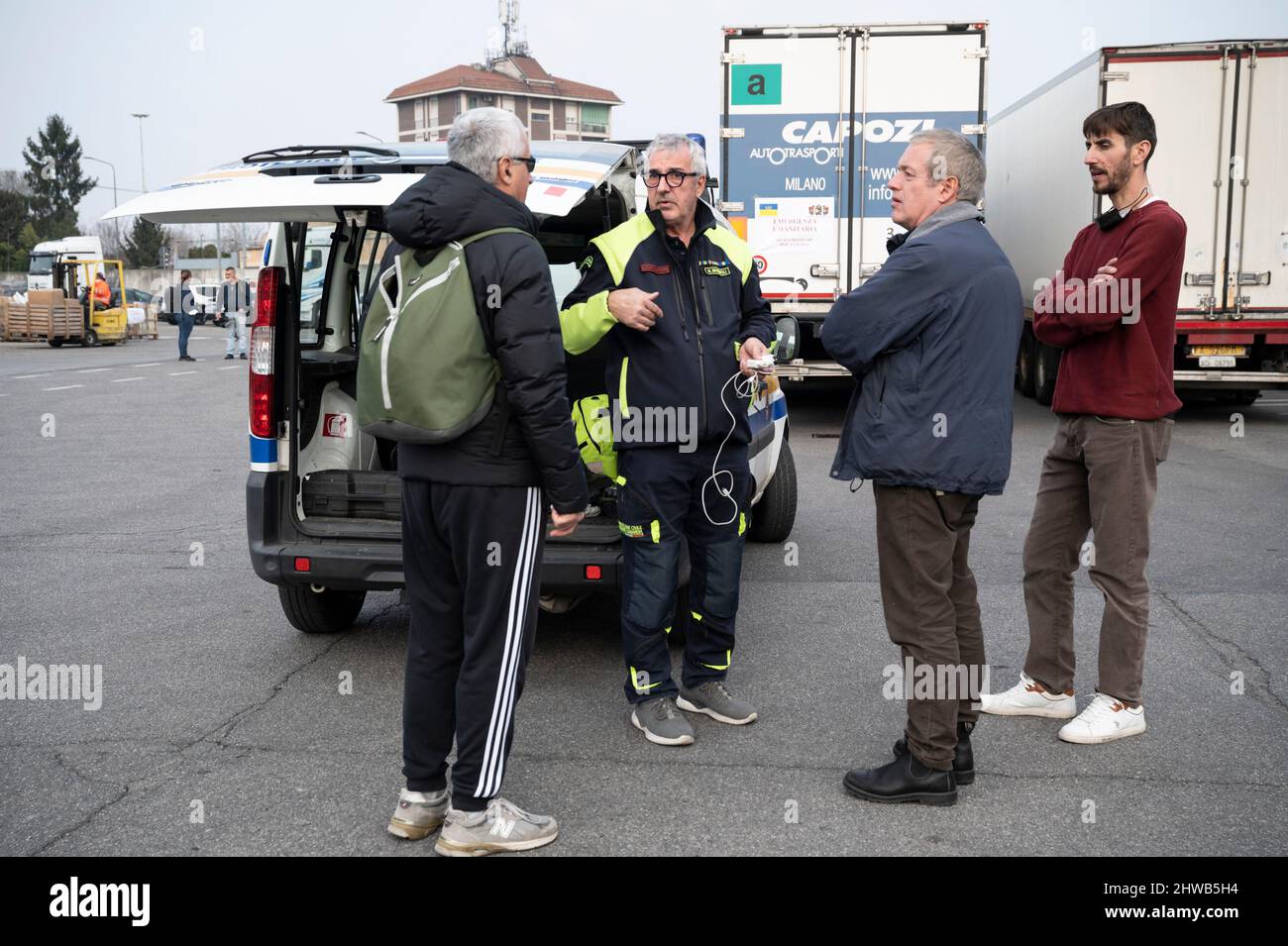 Milano, Italia. 04th Mar 2022. Un operatore della protezione civile parla con le persone in prossimità dei camion. Quasi 15 veicoli, con aiuti umanitari, organizzati dalla Chiesa Ortodossa di San Nicola e Ambrogio al Lazzaretto a Milano, partono il 4th marzo per portare abiti, cibo e beni di prima necessità alle persone ucraine, attraversando la Romania. L'Arcivescovo Avondios Bica guida il convoglio fino a Chernivtsi, Ucraina. Credit: SOPA Images Limited/Alamy Live News Foto Stock