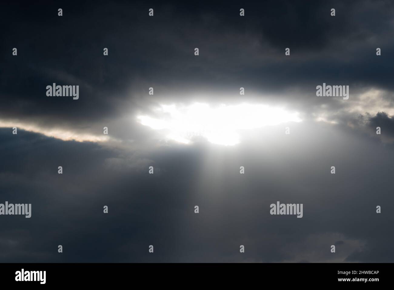 I raggi del sole si infrange attraverso il gap nelle nuvole scure - il tempo cambia con le nuvole dinamiche Foto Stock