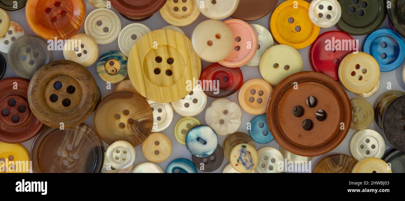 Molti bottoni colorati per indumenti in varie forme e dimensioni. Layout piatto, vista dall'alto Foto Stock