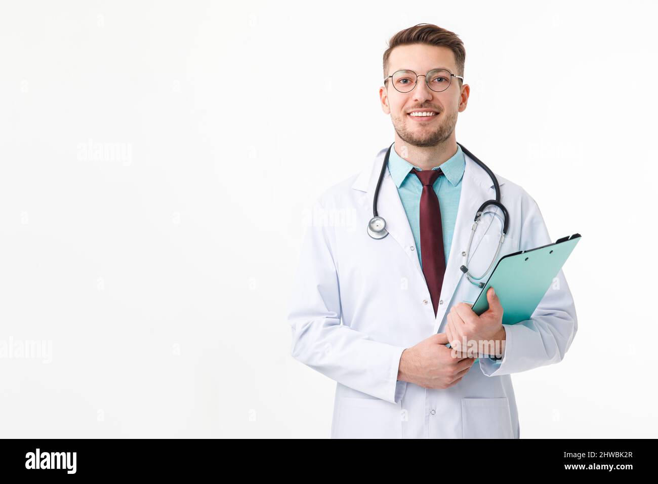 Ritratto di fiducioso giovane medico su sfondo bianco Foto Stock