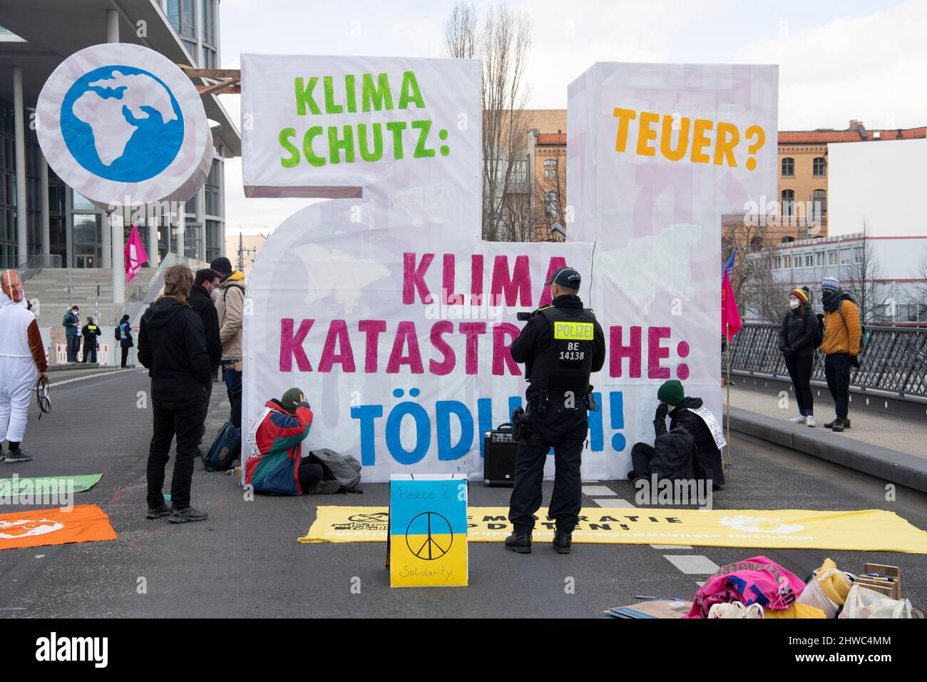 Berlino, Germania. 05th Mar 2022. I sostenitori e i sostenitori del movimento ambientale la ribellione dell'estinzione hanno occupato il Ponte Marshall con striscioni con l'iscrizione "catastrofe climatica: Mortale!" tra gli altri. Circa 50 attivisti hanno bloccato il ponte non lontano dal Reichstag. Con questa azione, essi sottolineano che, a loro avviso, l'obiettivo di limitare l'aumento della temperatura globale causata dall'effetto serra a 1,5 gradi Celsius non può essere raggiunto sulla base dell'ultimo rapporto mondiale sul clima. Credit: Paul Zinken/dpa/Alamy Live News Foto Stock